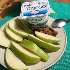 yogurt and sliced apples on a plate with nuts