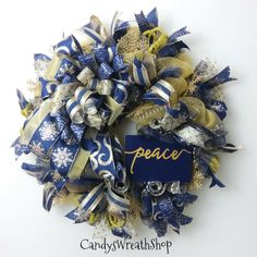 a blue and gold christmas wreath with peace on it