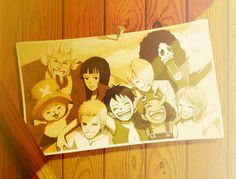 a group of anime characters on a piece of paper next to a wooden wall with wood planks