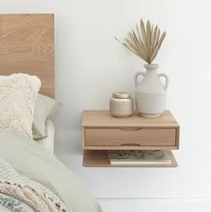 a bed with a wooden headboard and night stand next to the nightstand in front of it