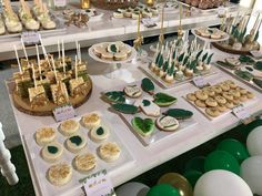 a table topped with lots of desserts covered in green and white frosted food