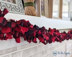 the red and black bow is hanging on the mantle