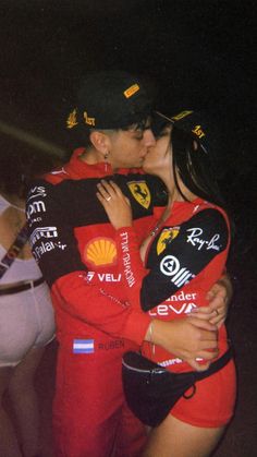 a man and woman kissing each other in front of people