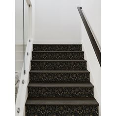 a set of stairs leading up to a bed in a room with white walls and blue carpet