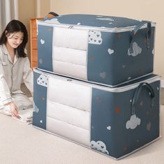 a woman sitting on the floor next to two suitcases that are both blue and white