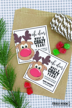 two christmas cards on top of a piece of brown paper next to some candies