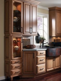 a kitchen with wooden cabinets and black counter tops, wood floors, and hardwood flooring