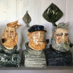 three statues of men with hats and beards