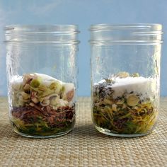 two jars filled with food sitting on top of a table