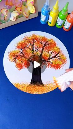 someone is painting a tree on the table