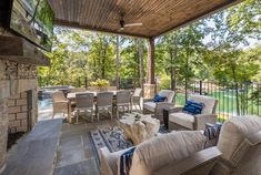 an outdoor covered patio with furniture and fireplace