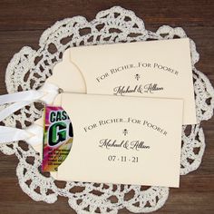 two wedding envelopes on a doily with ribbons