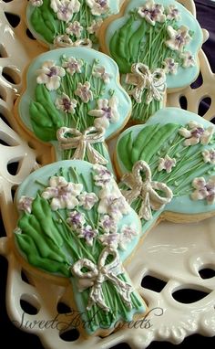 cookies decorated with flowers and leaves on a plate in the shape of a flower bouquet