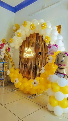 there is a baby shower with balloons on the floor and an animal balloon arch next to it