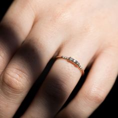 a woman's hand with a diamond ring on top of her finger, showing the band