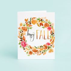 a card with the words happy fall written in gold foil on it, surrounded by watercolor flowers