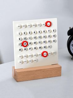 an alarm clock sitting on top of a wooden stand next to a black and white clock