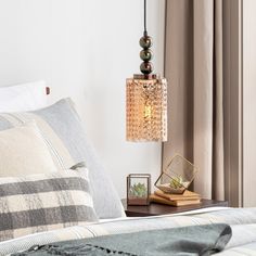 a bedroom with a bed, nightstand and hanging light fixture in it's corner