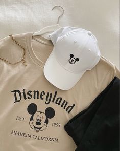 Neutral beige Mickey Mouse disney shirt with black leggings and white Mickey Mouse baseball hat. Disneyland Outfits Summer Mom, Minimalist Disney Shirt, Aesthetic Disney Shirts, Mickey Mouse Shirt Ideas, Disney Clothes Aesthetic, Disney Mom Aesthetic, Neutral Disney Outfits