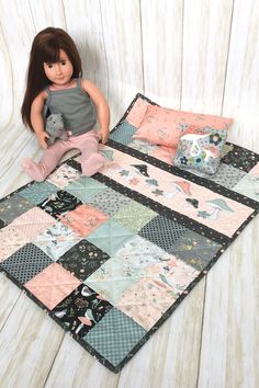 a doll sitting on top of a patchwork quilt