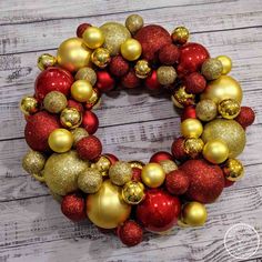 a wreath made out of red and gold ornaments on a white wooden background with text overlay