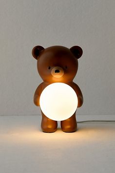 a brown teddy bear holding a white light