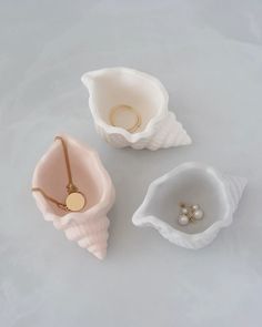 three seashells with rings on them sitting next to each other