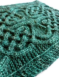 a close up view of a green knitted scarf