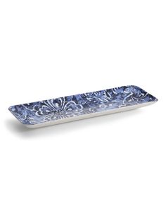 an ornate blue and white serving tray with flowers on the bottom, in front of a white background