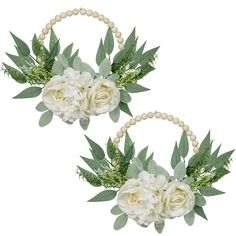 two white flowers and greenery are in the hoop