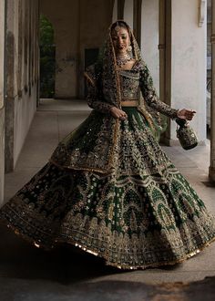 a woman in a green and gold bridal gown is standing on the floor with her handbag