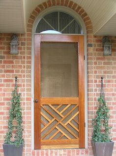 a wooden door with two planters next to it