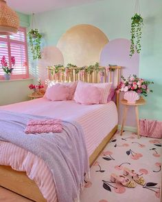 a bedroom with pink bedding and flowers on the wall