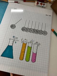 a notebook with an image of different colored beaks and flasks on it