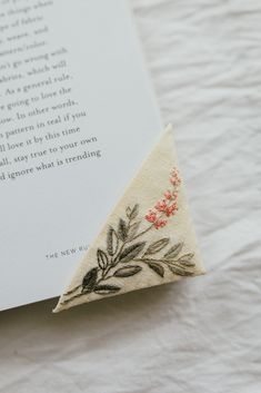 an open book with embroidered flowers on it