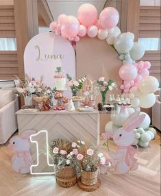 a table topped with lots of balloons and flowers next to a sign that says luna