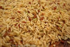 brown rice with red and green seeds on a wooden surface, ready to be eaten