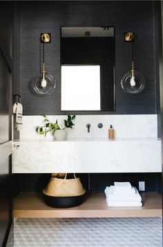 a bathroom with black walls and marble counter tops