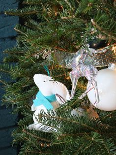 an ornament in the shape of a bear hanging from a christmas tree branch