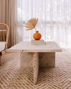 a coffee table with a book on it and a vase sitting on top of it