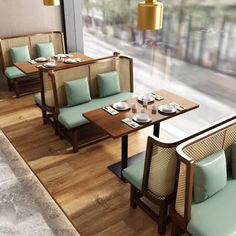 an empty restaurant with wooden tables and green chairs next to a large window looking out onto the street