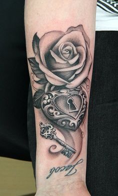 a rose and key tattoo on the arm with an open heart in the shape of a lock