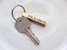 a metal keychain with a name tag attached to it on a white plate