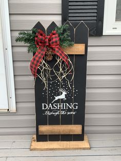 a wooden sign with a bow on it that says dashing through the snow