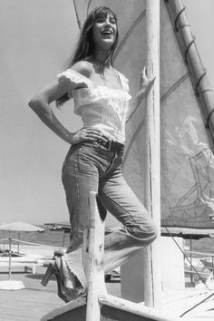 a woman standing on top of a sail boat