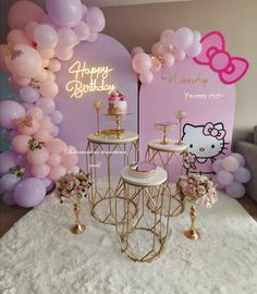 a hello kitty themed birthday party with balloons and cake table set up in front of a hello kitty backdrop