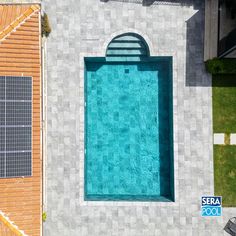 an aerial view of a swimming pool with solar panels on the roof and above ground