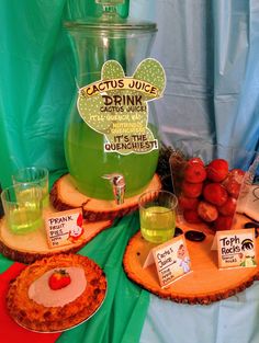 the table is set up with various drinks and desserts on wooden slices, including apples