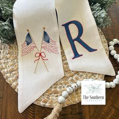 two white towels with red, white and blue flags on them sitting on a table