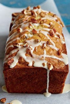 a loaf of bread with icing and nuts on top